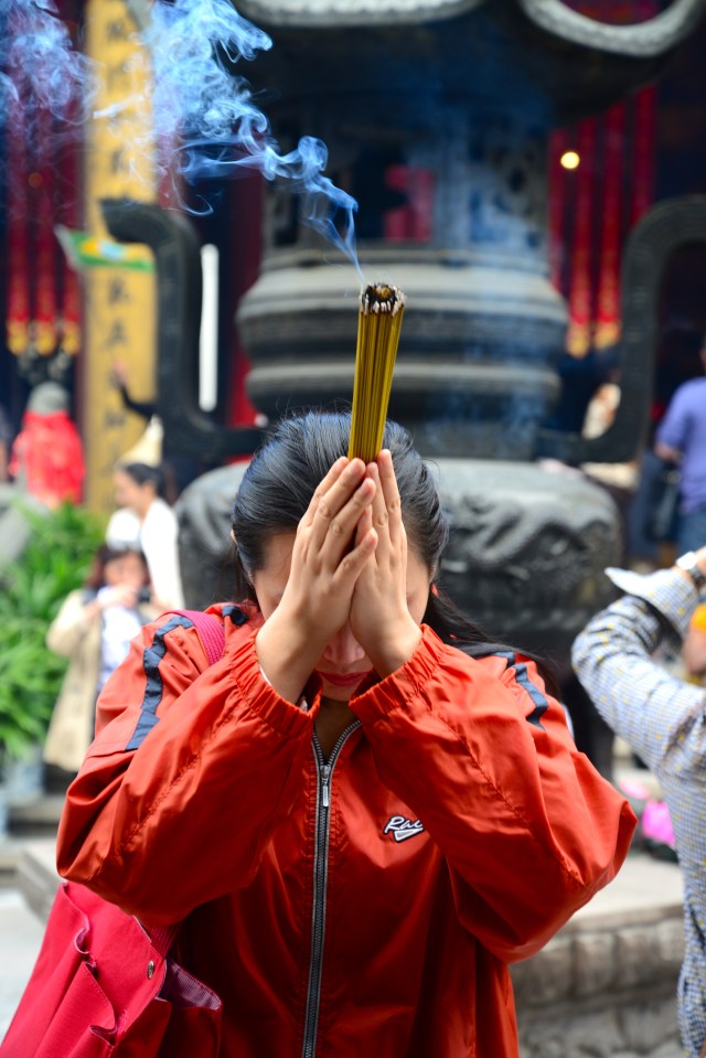 Fiel em oração no Templo Budista.