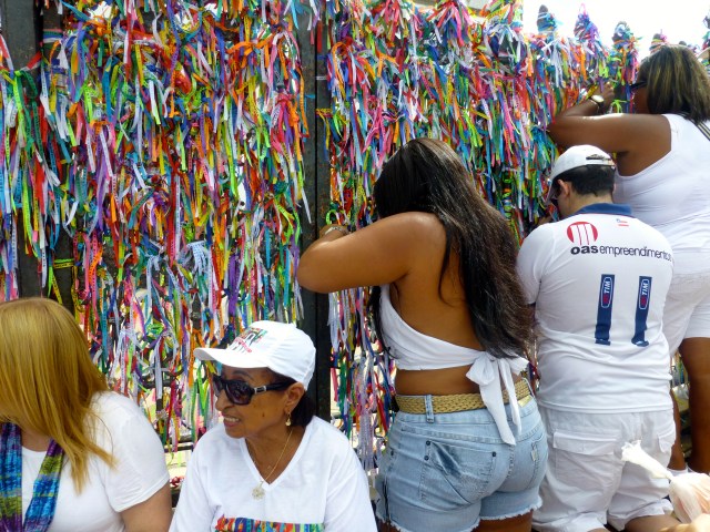 A igreja fica fechada, mas os fiéis oram na escadaria.