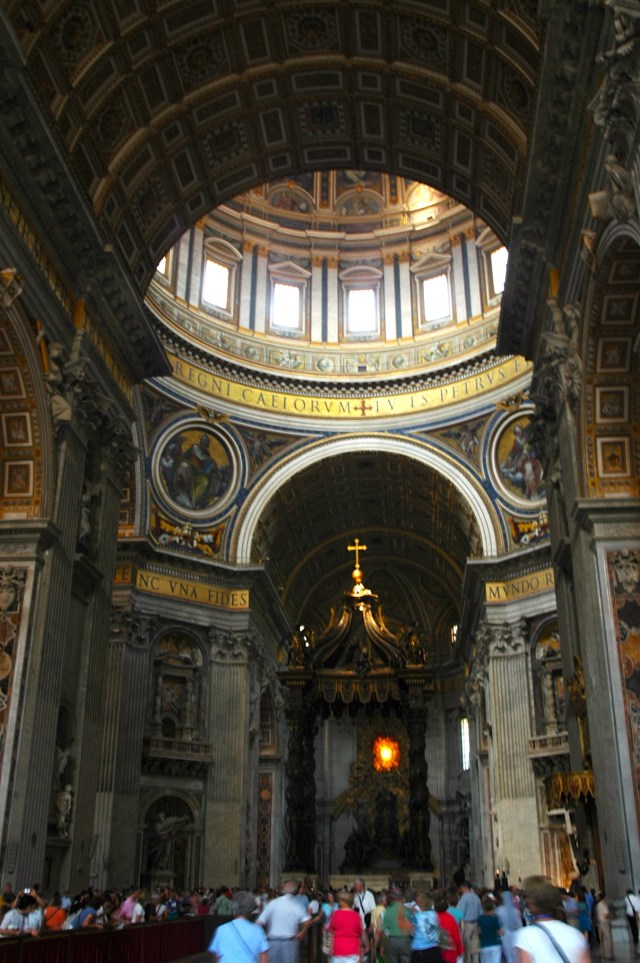 O interior da Basílica de São Pedro com o Domo de Michelangelo ao fundo.