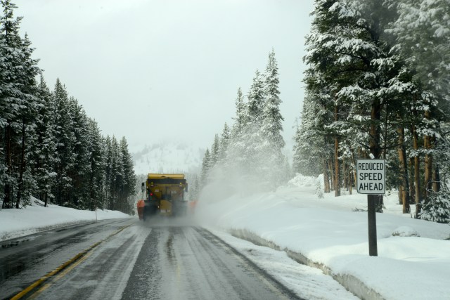 Caminhão limpando a neve da estrada.