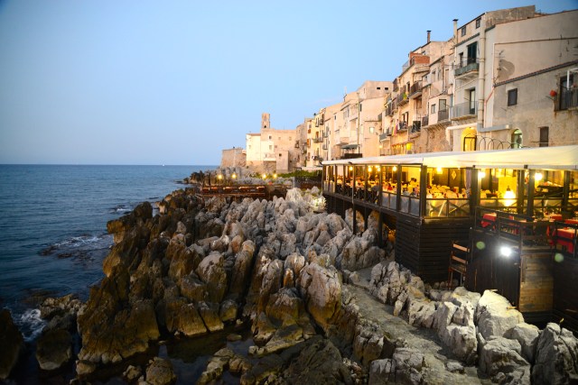 Os restaurantes com as varandas sobre o mar em Cefalú.