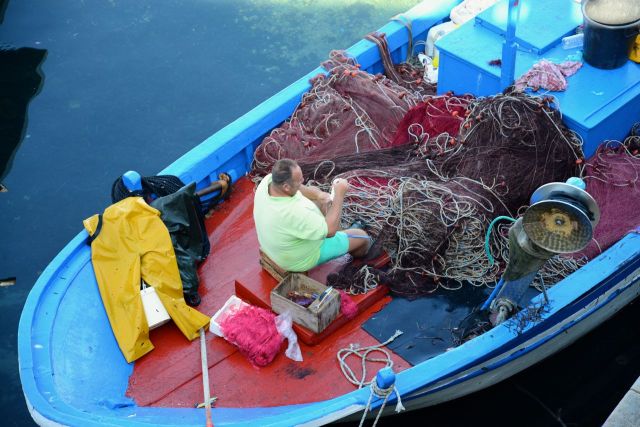Pescadores consertam redes na costa de Gallipoli.
