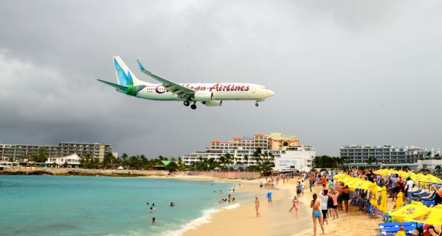 O avião passa sobre as cabeças dos banhistas.